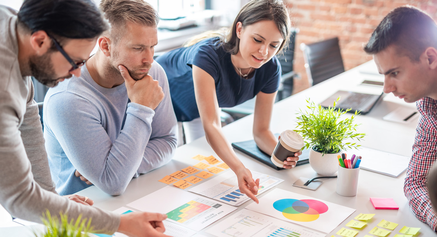 People at a desk creating a direct mail campaign