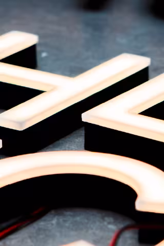 Illuminated custom signage with raised lettering, demonstrating bespoke graphic and visual branding solutions.