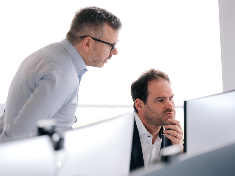 Two male colleagues working at a screen